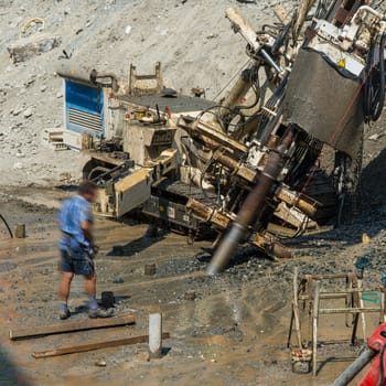drill rig in action on the bed of a stream to work on the site