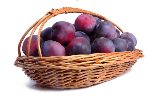 Wicker basket placed in her large ripe plums