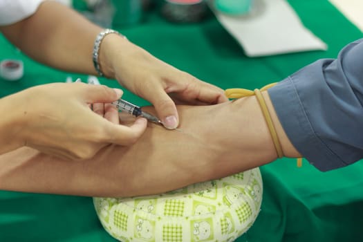 A young woman injecting hypodermic into  arm