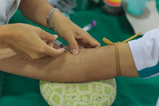 A young woman injecting hypodermic into  arm