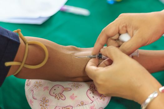 A young woman injecting hypodermic into  arm