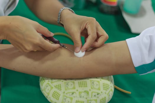 A young woman injecting hypodermic into  arm