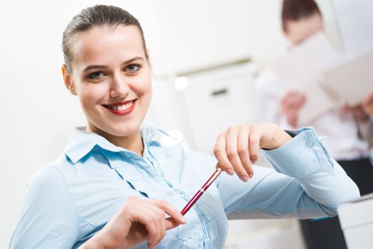 portrait of a business woman in office, smiling and looking into the camera, office work