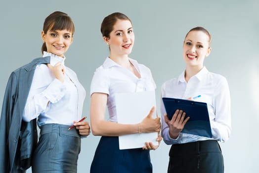 three business women standing in a row and smiling, teamwork in business