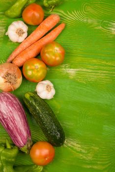 Fresh vegetables arranged on a  green wood background