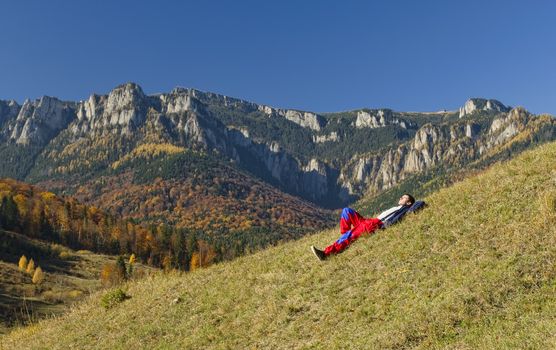 young man resting in autumn seasonal mountain landscape, Romania