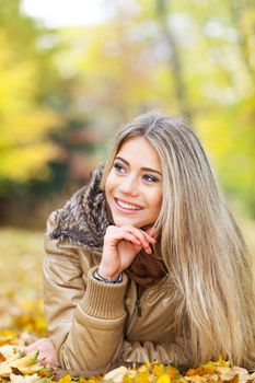 Pretty smiling girl lying in a park and looking something