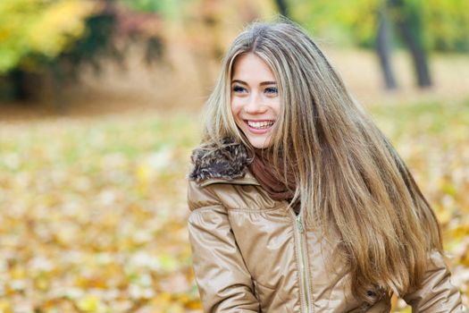 Young smiling woman in a park in autumn