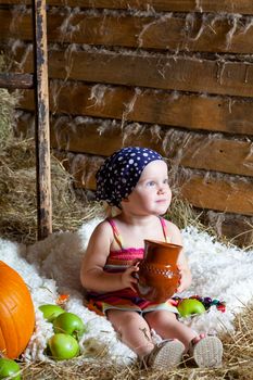 little girl sits on a mow with a milk jug