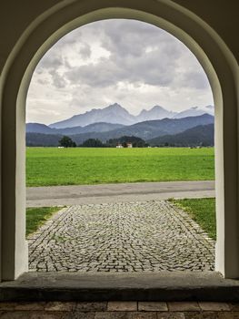 Picture of Allgau mountains in feet from a doorway of a Church near Fussen, Allgau, Bavaria, Germany