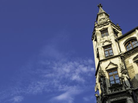 Closeup of a small tower on the city hall in Munich in the evening sun and blue sky