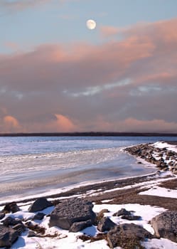 moon and snowy winter coastline scene