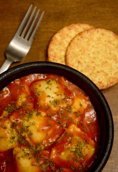 cheese ravioli with crackers and fork in rustic italian setting