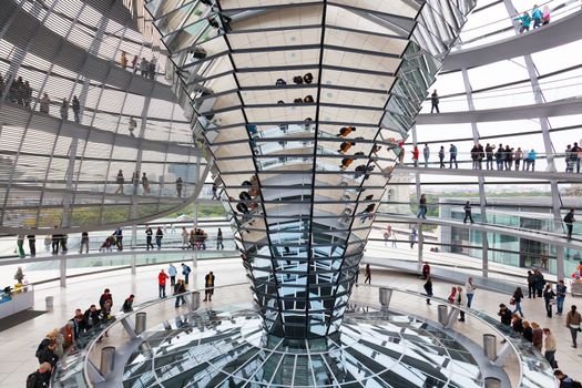 BERLIN, GERMANY - SEPTEMBER 24:Tourists under Reichstag dome, September 24, 2012, Berlin, Germany. After moving of the Bundestag to Berlin in 1999 the building of the Reichstag was visited by over 13 million people from all over the world: