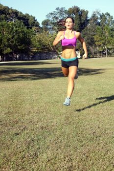 A lovely young athlete with remarkable abdominal musculature jogging outdoors.  Generous copyspace.