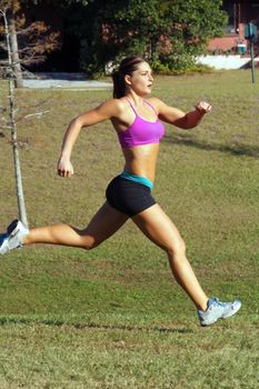 A lovely young athlete sprinting outdoors.