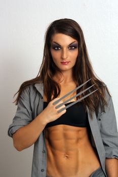 A lovely young brunette with extraordinary abdominal musculature and sharp metal claws extending from her hand.