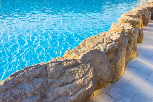side of the pool is edged with stone