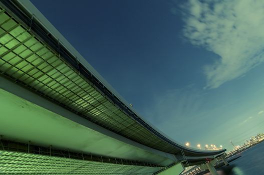 huge highway structure going faraway over night river waters in Tokyo, Japan