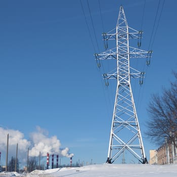 huge pylon over clear blue sky with many chimneys on background