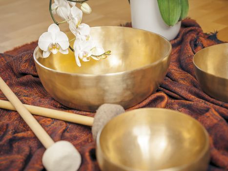 An image of some singing bowls and a white orchid