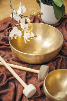 An image of some singing bowls and a white orchid