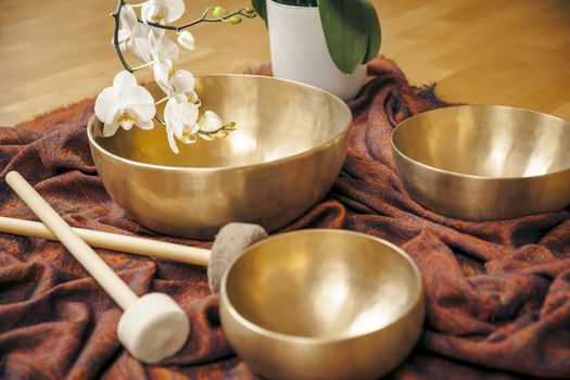 An image of some singing bowls and a white orchid