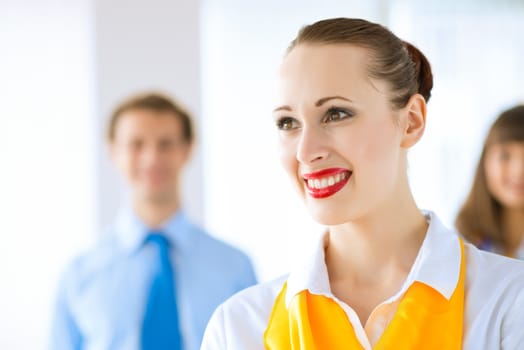 Portrait of a young successful business woman standing against colleagues