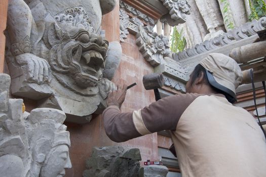 BALI, INDONESIA-JUNE 25TH: A sculptor at work on a temple in Ubud on 25th June 2012. Bali is famous for its many craftsmen.