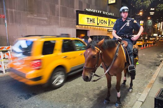NEW YORK CITY, USA - SEPTEMBER 21: Police officer rides her horse downtown in New York on the main street, Manhattan on September 21, 2012. Times Square, New York, USA