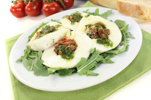 fresh stuffed mozzarella with dried tomatoes on a light background