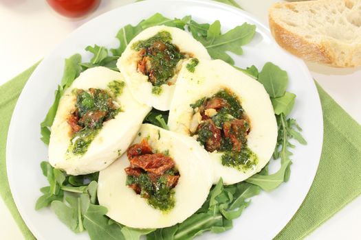 stuffed mozzarella with dried tomatoes and basil on a light background