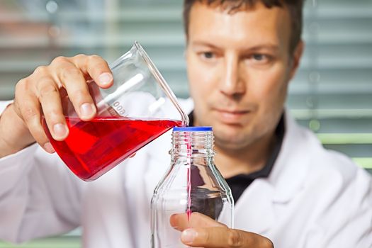 A man with a red liquid in the laboratory