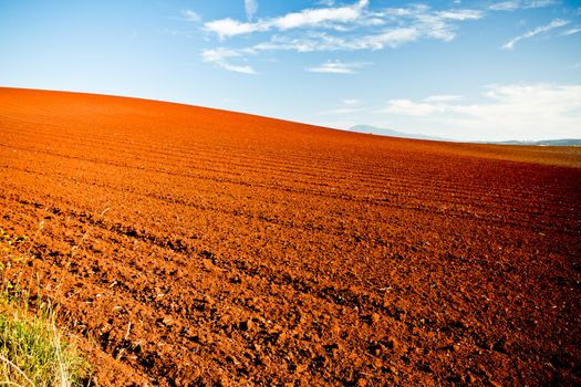 Red earth in newly turned and ploughed agricultural fields under a blue summer sky in a beautiful Australian landscape
