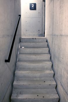 concrete staircase and stairs leading upwards to second floor of parking garage