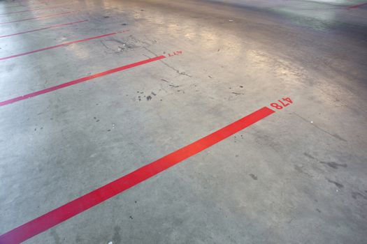 red lines and numbers on the floor of empty parking garage