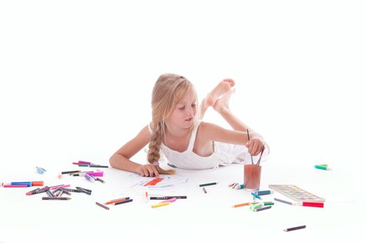 young girl painting with watercolor on floor of studio against white background