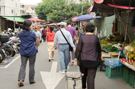 TAIPEI, TAIWAN - October 9 : A group of old people walk toward the traditional marketplace to shop on October 9, 2012 in Taipei, Taiwan, Asia.