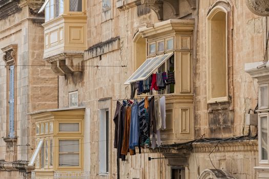 Laundry hangs out of one of the beautiful wooden balconies in Valletta.