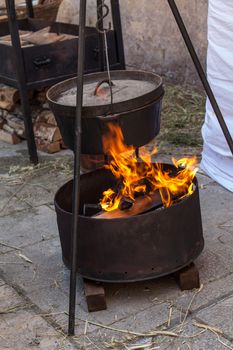 An old iron cooking stove on open burning flame