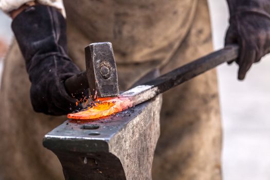 Blacksmith working on metal on anvil at forge high speed detail shot