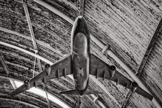 Old aircraft model hanging from a hangar ceiling