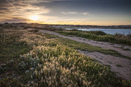 A beautiful spring sunset over the idyllic setting of St. Thomas Bay in Malta.