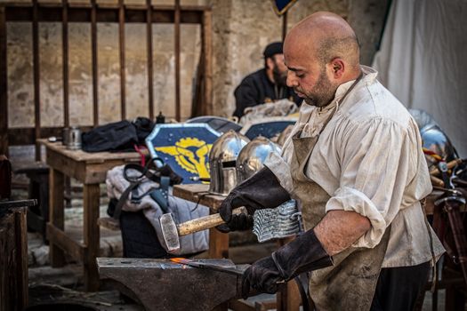 MDINA, MALTA - APR 13 - A medieval blacksmith during the Medieval Mdina festival in Mdina on 13 April 2013