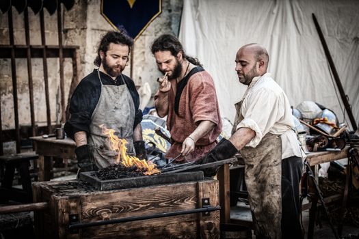 MDINA, MALTA - APR 13 - A medieval blacksmith during the Medieval Mdina festival in Mdina on 13 April 2013