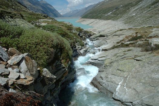 Stream and lake nearby mattmark dam in Alps in Switzerland