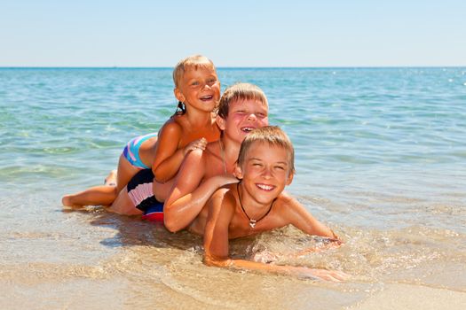 Three kids enjoying summer day on a beach