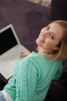 attractive young smiling woman on couch with notebook 