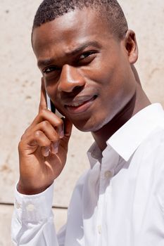 young successfil african businessman with mobilephone talking walking outdoor