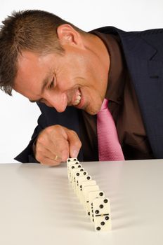 Guy having fun with a row of domino stones